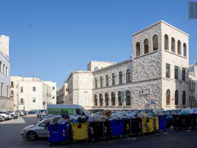 ...un piazzale da tempo adibito a parcheggio e occupato da strabordanti bidoni dell�immondizia